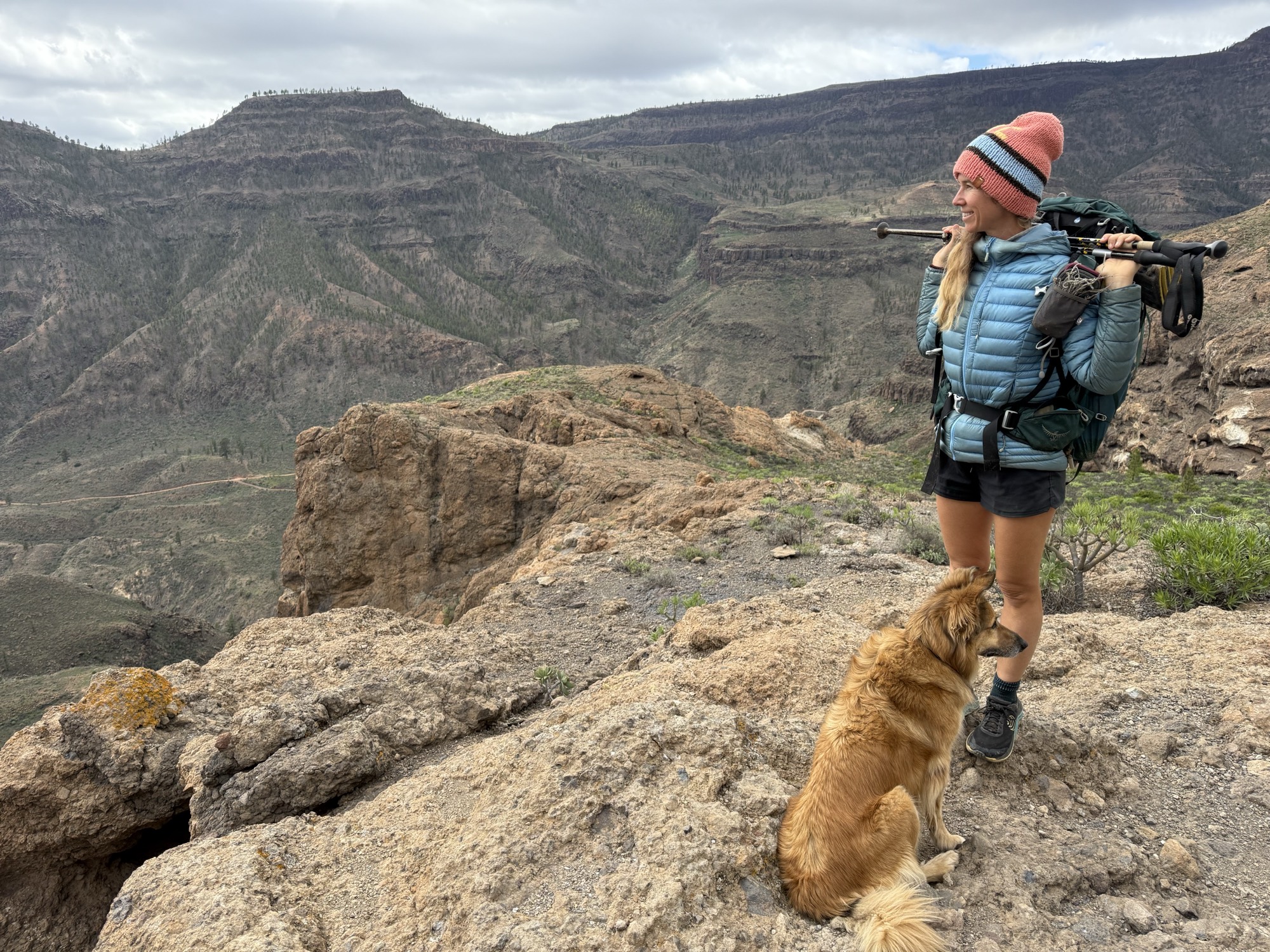 Suzanne and her dog Wingo on a rocky cliff above a canyon